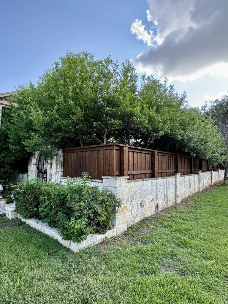 Cedar board-on-board fence on Austin stone wall in Pearland, TX